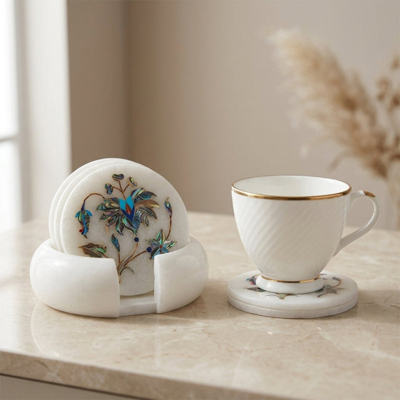 White marble coaster set with gemstone inlay beside a coffee cup