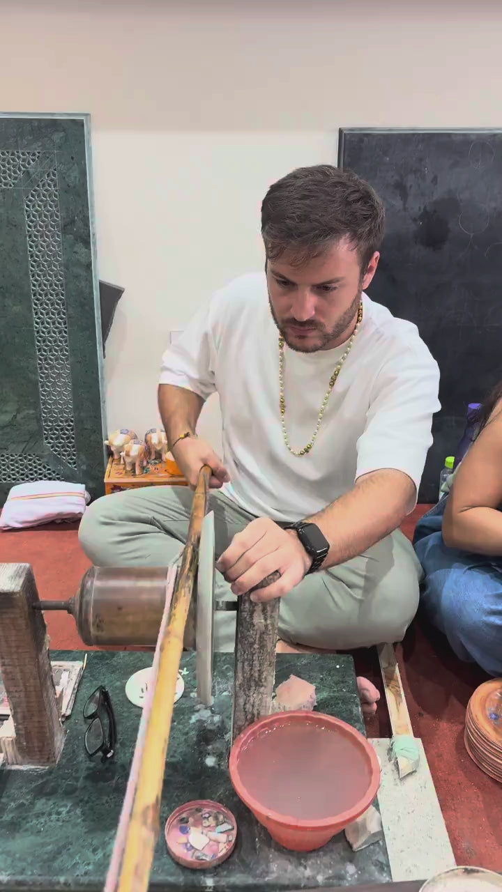 Visitor shaping stone at the wheel with gemstones shown on screen